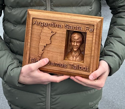 Wooden plaque with engraved text and a portrait, held by a New Missionary